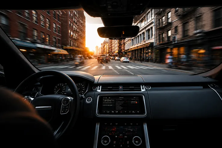 Driver's-eye view through a windshield at sunset