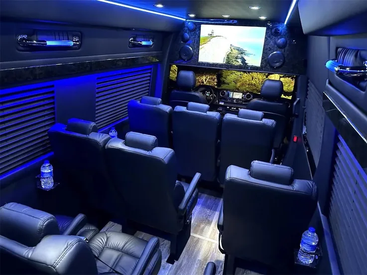 Sprinter interior looking forward, with blue lighting and captain's chairs