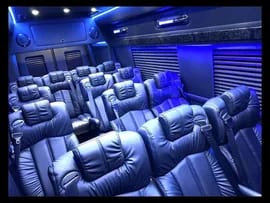 Rows of blue-lit leather seats in a Sprinter interior